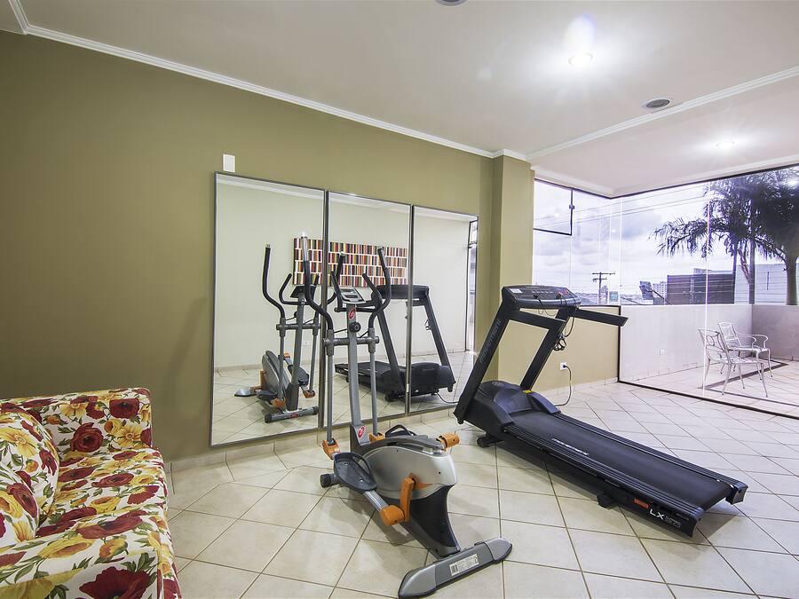 A home gym with exercise equipment, a large mirror, and a view of the outdoors.