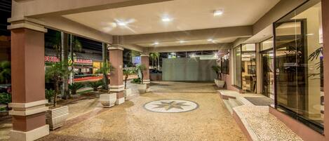 Entrada de hotel con piso de baldosas, un diseño de estrella y una puerta de cristal a la derecha.