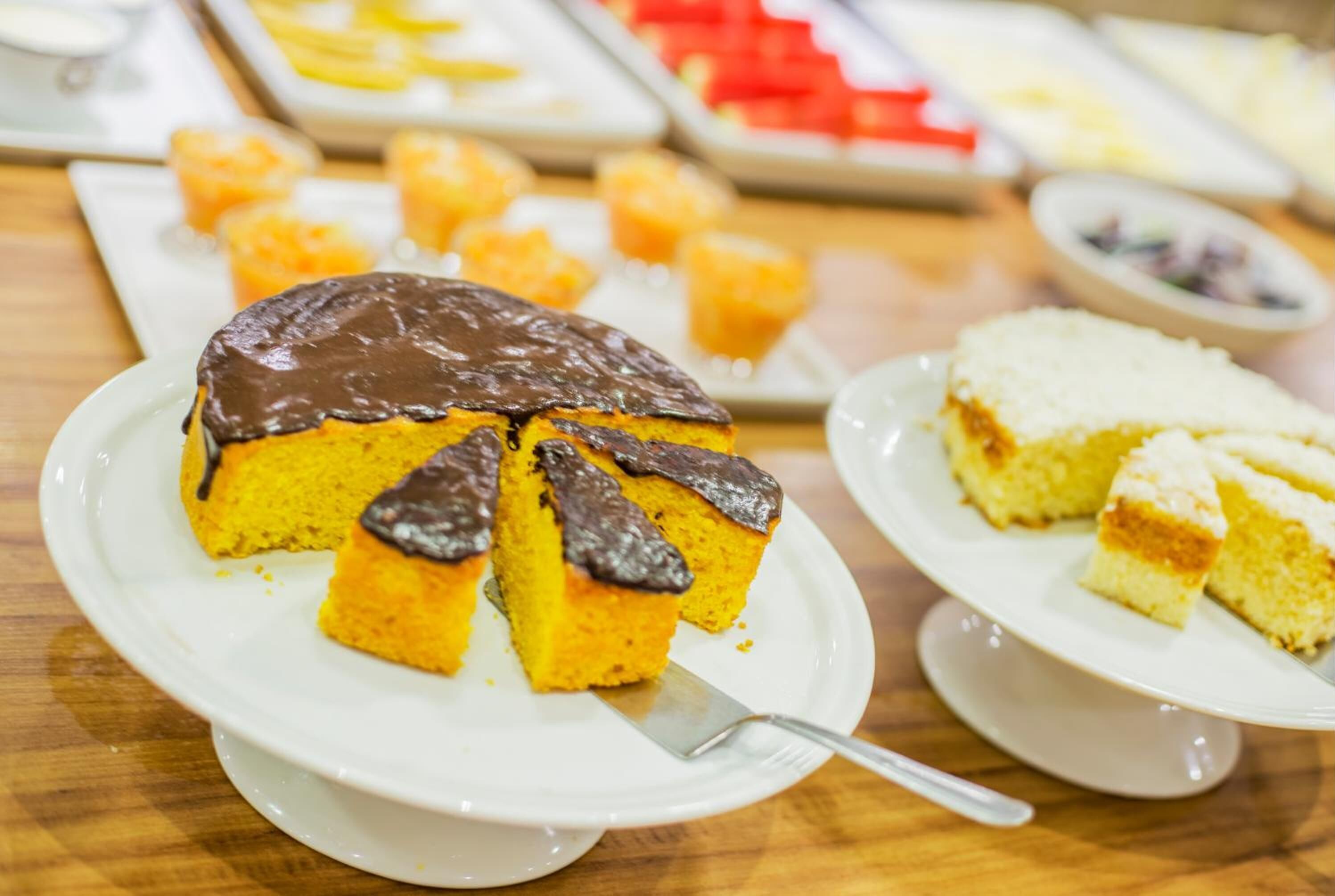 A dessert table with various cakes and pastries.