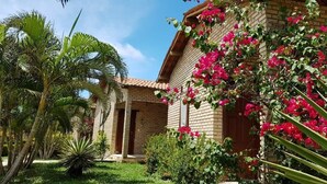 Un edificio de ladrillo con jardín y palmeras.