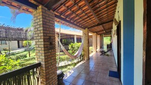 A covered outdoor area with a hammock, brick pillars, and a tiled floor. - Eco Resort Vento Leste (Jijoca de Jericoacoara)