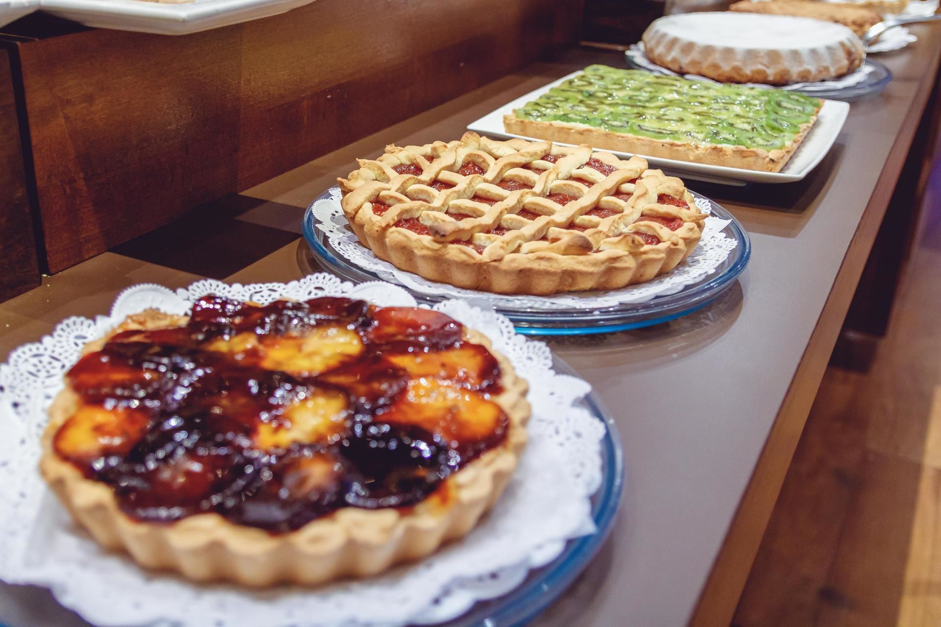 A buffet table with various pies and desserts.