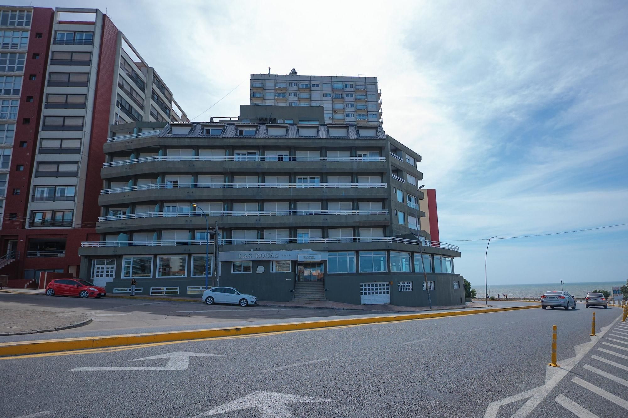 A multi-story hotel with a curved facade, located near a waterfront.
