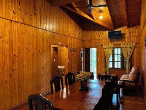 A wooden interior with a dining table, chairs, a sofa, and a television. - Costa del Sol Iguazú (Puerto Iguazú)