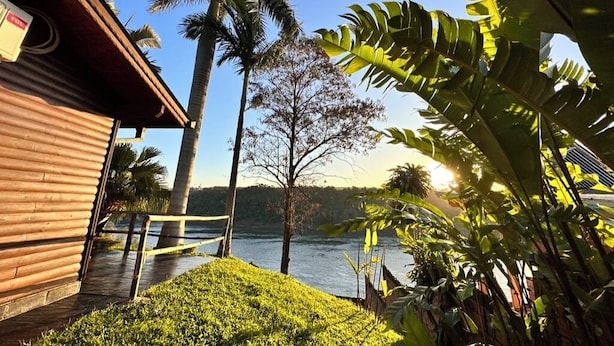 Un edificio de madera con vistas a un lago y palmeras.