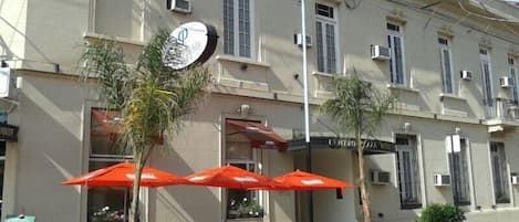 A building with outdoor seating and palm trees.