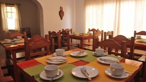 A dining area with multiple tables and chairs, each set with plates, cups, and cutlery. - Yr Hen Ffordd (Gaiman)
