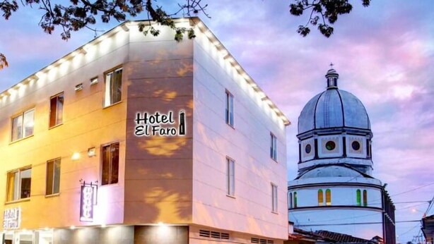 A hotel named "Hotel El Faro" with a modern facade, a dome structure, and a street view at dusk. - Hotel El Faro Buga (Guadalajara de Buga)