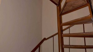 Una escalera de caracol con barandillas de madera y techo rojo.