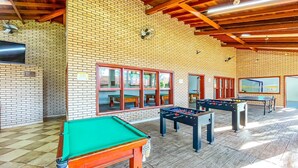 Une salle de loisirs équipée de tables de billard, de baby-foot et d’une table de jeu de flipper.