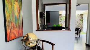 A room with a wooden chair, a globe, and a large potted plant. - Hotel Casa del Sol (Managua)