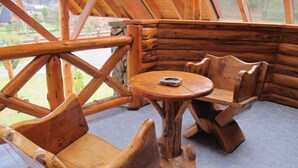 Un intérieur rustique en bois, avec une table ronde et des bancs.