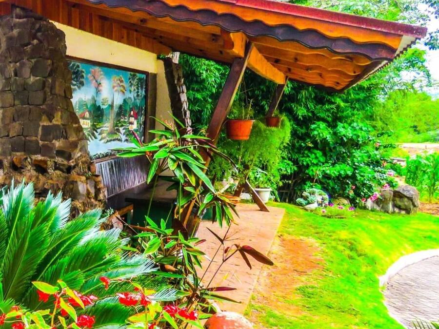 Un edificio rústico con un muro de piedra, un porche de madera y un mural.