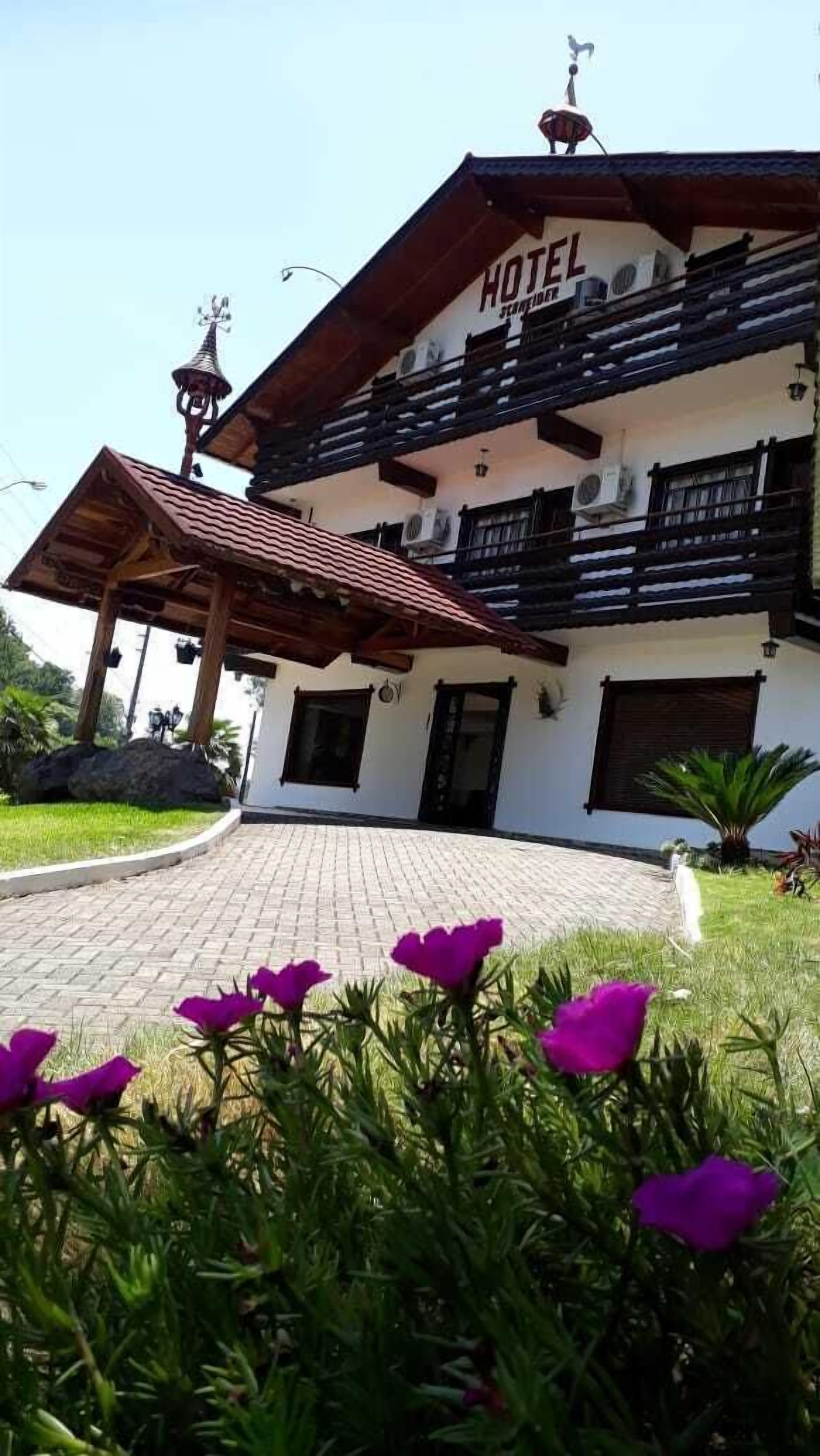 Um edifício de dois andares com uma placa que diz "HOTEL" e varandas.