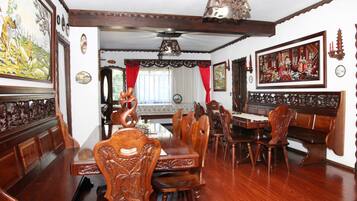 A dining room with wooden furniture, a chandelier, and wall art.