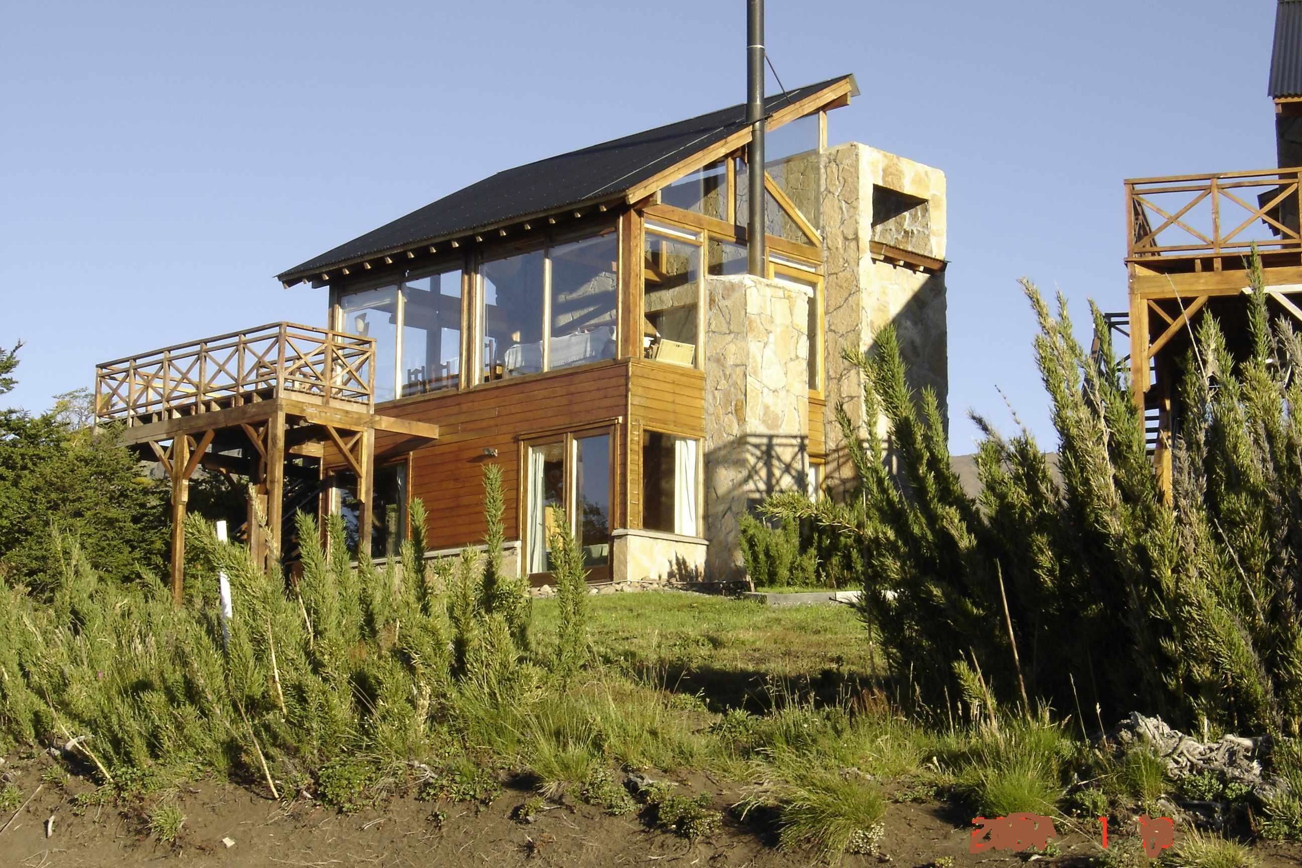Un edificio moderno con terraza de madera y ventanas amplias.