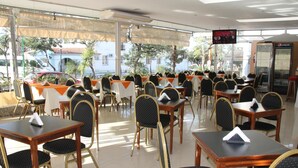 An outdoor restaurant with tables and chairs, a television screen, and a Pepsi refrigerator. - Hotel Bristol (Termas de Rio Hondo)
