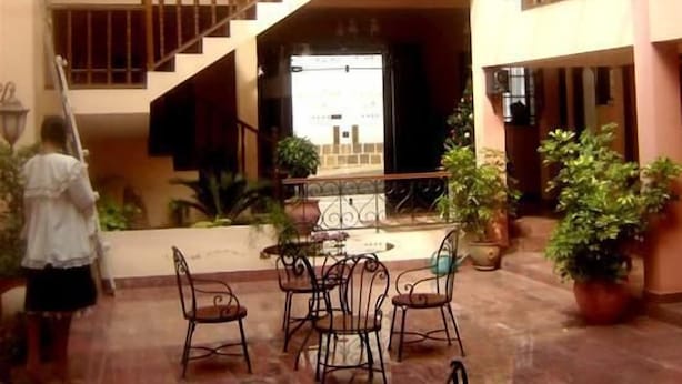 A courtyard with a staircase, outdoor seating, and potted plants. - Hostal Santa Teresa de Jesús (Sucre)