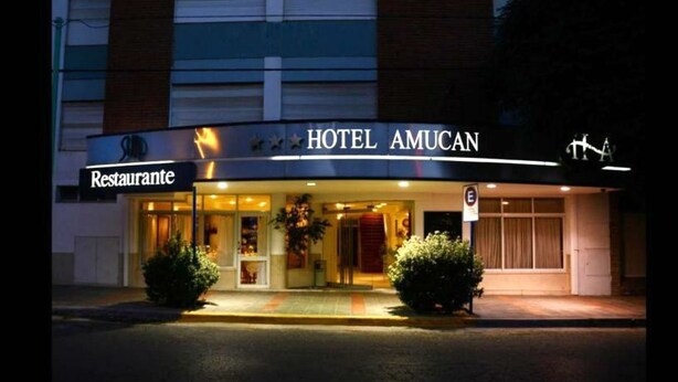 Un hotel con restaurante llamado "Hotel Amucan" y un letrero que indica zona sin estacionamiento.