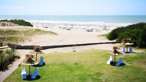 Na praia, espreguiçadeiras, toalhas de praia 