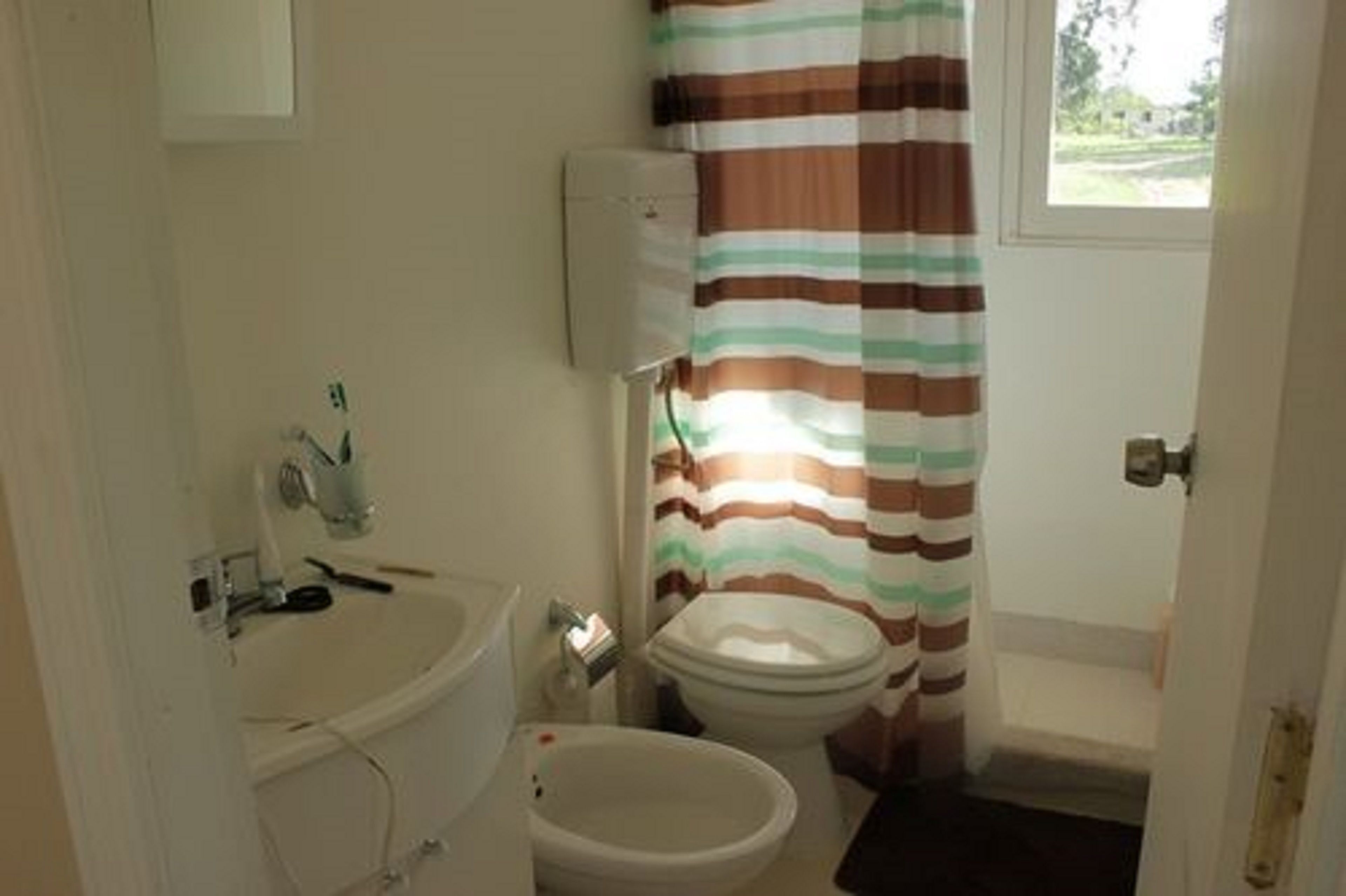 A small bathroom with a toilet, bidet, and sink.