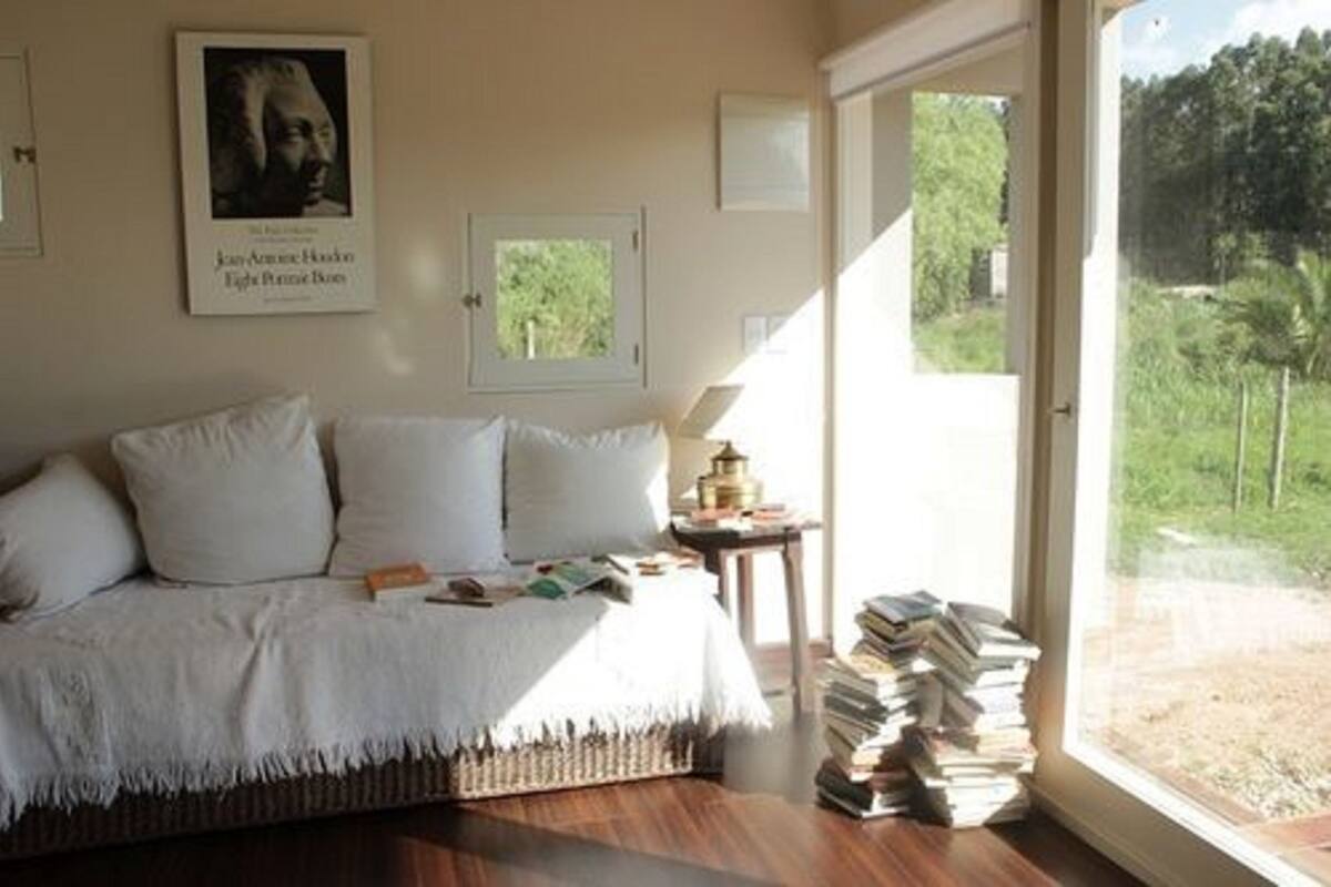 Ein Zimmer mit einem Bett, einem Fenster und einer Büchersammlung.