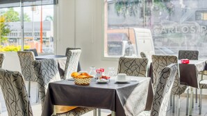 A dining area with tables set for breakfast, featuring bread, pastries, and condiments. - Hotel Casa Nostra (Villa Carlos Paz)
