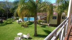 A backyard with a swimming pool, a small garden, and a staircase leading to a building. - Hotel Paraíso Termal (Federacion)
