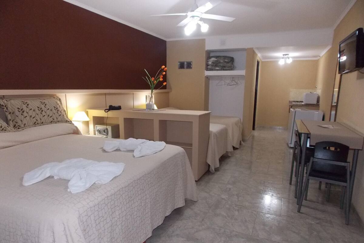 Une chambre d’hôtel avec un lit, un bureau, une chaise et une petite table.
