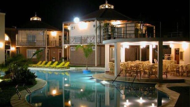 A hotel with a swimming pool, outdoor seating, and a well-lit terrace. - Hotel Paraíso Termal (Federacion)