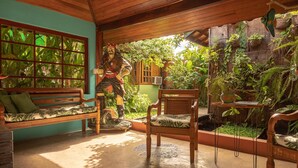 Interior de madera con una estatua, un banco y una silla.