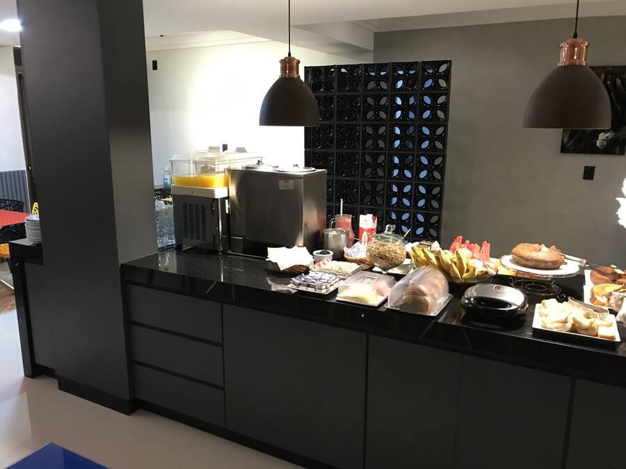 Une cuisine moderne avec un plan de travail noir, divers produits alimentaires et une machine à café.