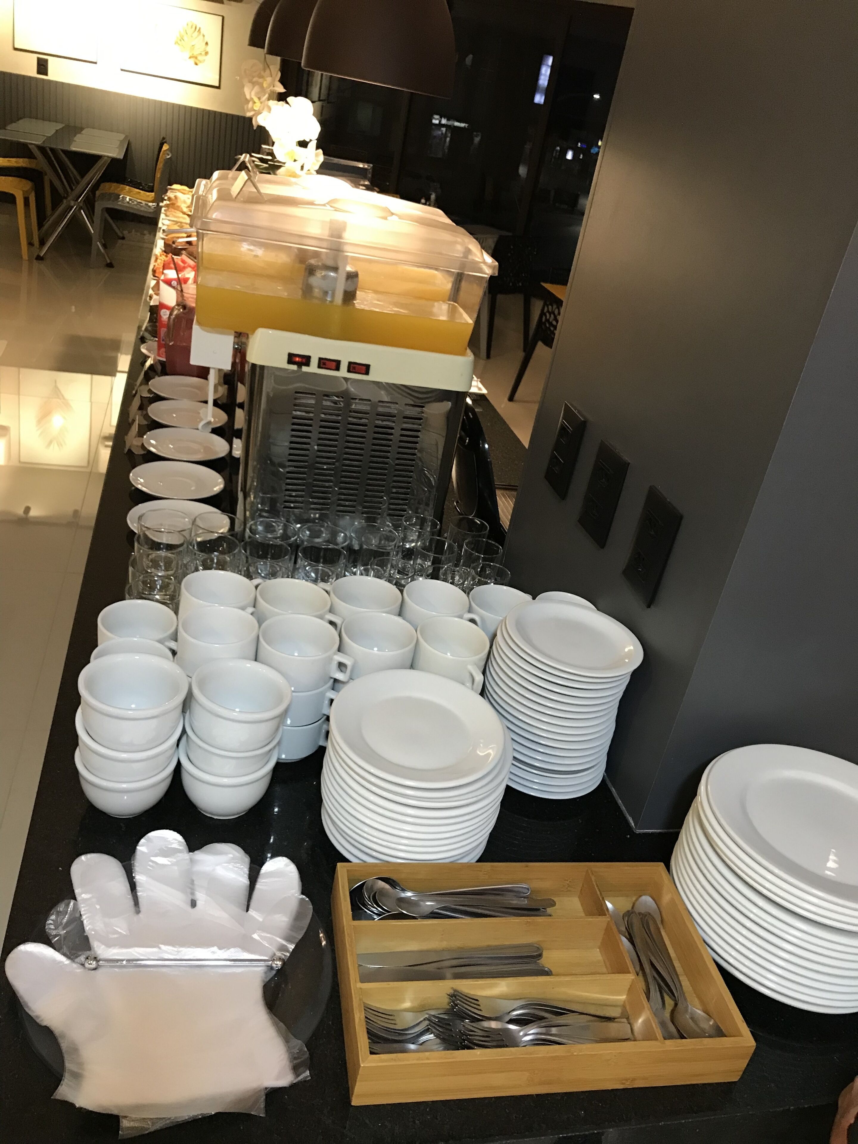 A buffet setup with various dishes, glasses, and utensils neatly arranged on a counter.