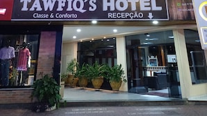 L'hôtel Tawfiq dispose d'un hall d'accueil, de plantes en pot et d'une enseigne indiquant « Classe et Confort ».