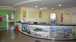A reception area with a counter, a fire extinguisher, and informational posters on the walls. - Hotel O Compadre (Porto Velho)