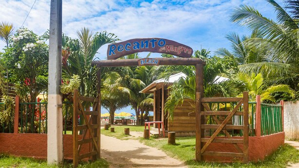 Una verja de madera con un letrero que dice "Recanto dos Milagres Beach".