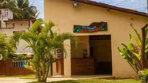 Un restaurante llamado 'Restaurante do Milagro' con un mostrador de recepción de madera y un cartel.