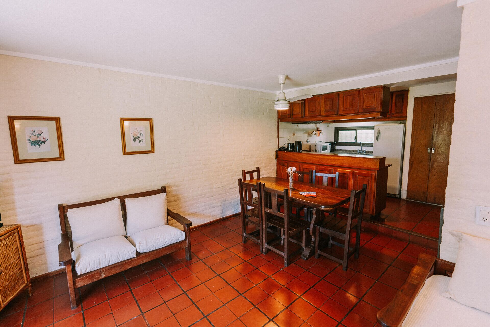 A compact living space with a kitchenette, a dining area, and a sofa.