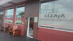 A building with a large sign for S.I.J.A. and a logo for Posada La Alemana. - Posada La Alemana (Puerto Iguazu)