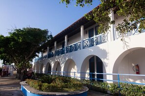 A building with a white facade, blue balcony railings, and arched windows.