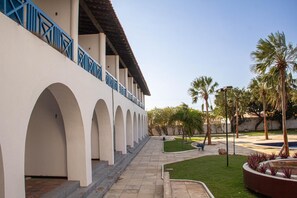 A building with a series of arches and a covered walkway. - Arrey Rio Poty Hotel Praia (Luis Correia)