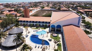 A hotel with a swimming pool, palm trees, and a view of the beach. - Arrey Rio Poty Hotel Praia (Luis Correia)