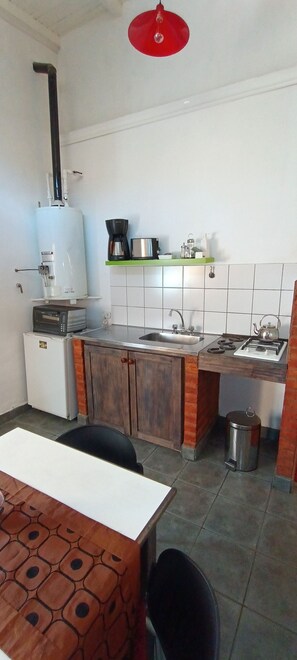Una cocina compacta equipada con refrigerador, microondas, estufa y lavaplatos.