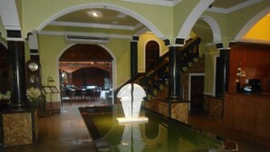 A lobby with a central reflective water feature, arched ceilings, and a staircase leading to upper floors. - Del Pomar Hotel Boutique (Resistencia)