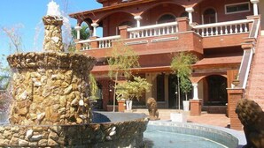 A hotel with a stone fountain and a lion statue in front. - Del Pomar Hotel Boutique (Resistencia)
