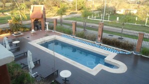 A swimming pool with a surrounding deck, lounge chairs, and a small brick structure. - Del Pomar Hotel Boutique (Resistencia)