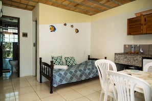 A compact room with a bed, a dining table, and a kitchen area. - Pousada Natureza Florianopolis (Florianópolis)