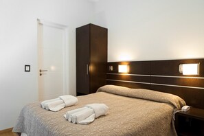 Ein Hotelzimmer mit einem Bett, einem Kleiderschrank und einem Nachttisch.