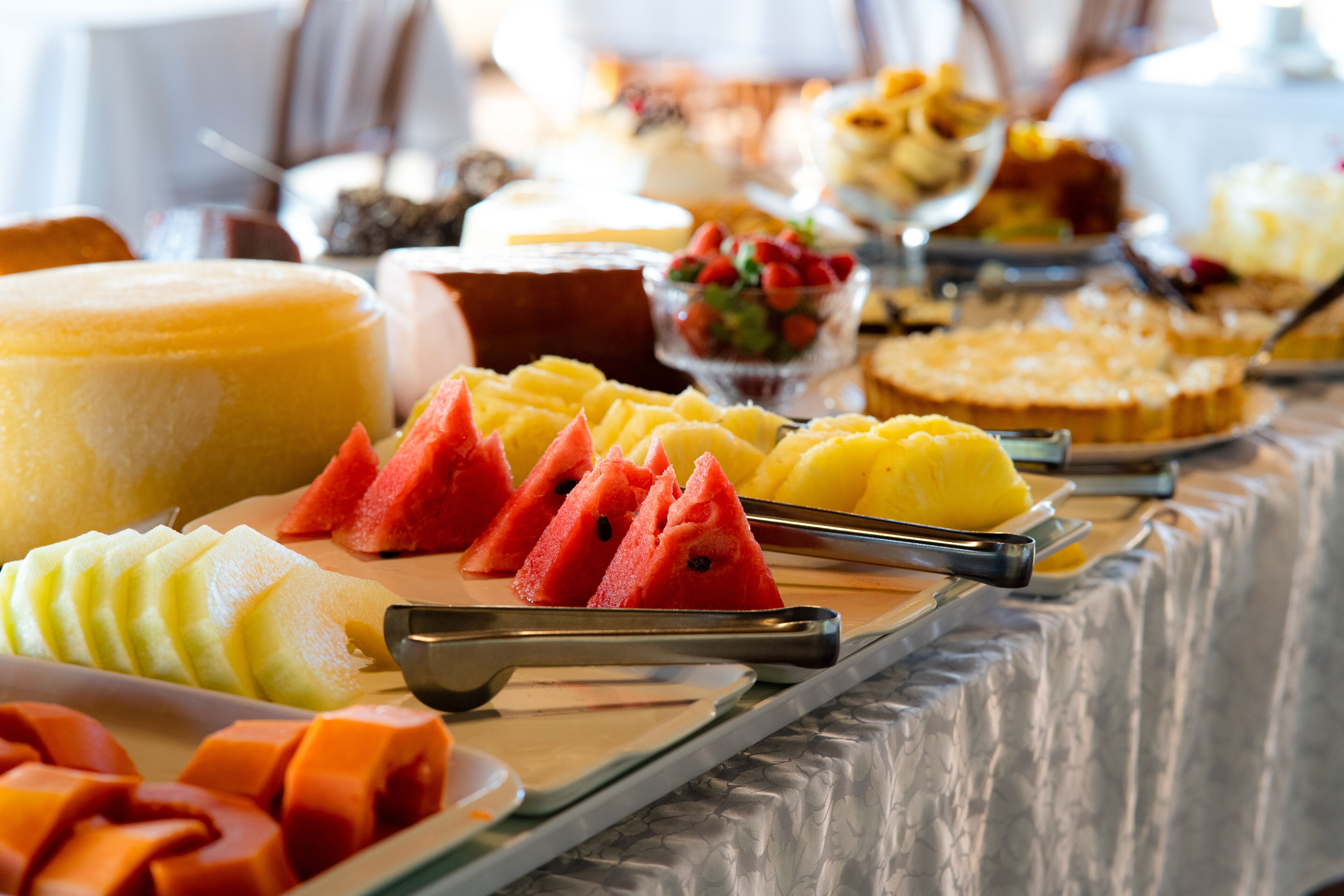 A buffet with various fruits and desserts.