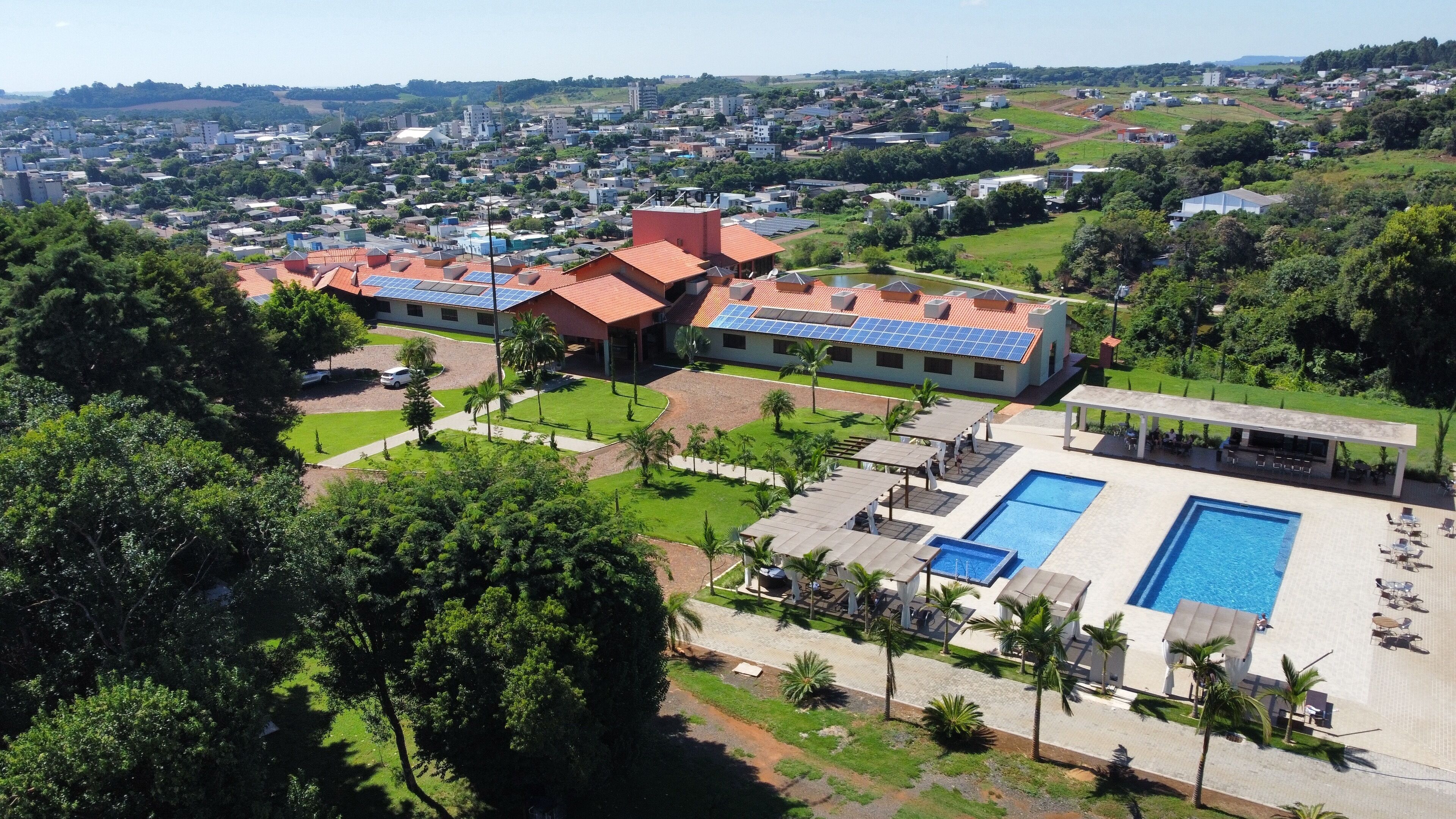 Et resort med flere bygninger, en swimmingpool og frodigt grønt område omkring.
